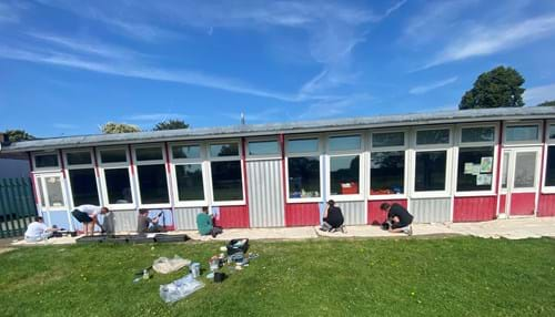 volunteers painting the front of Drapers Pyrgo Priory School