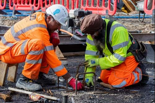 2 construction workers installing remote sensors