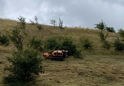 An  orange piece of machinery in a field