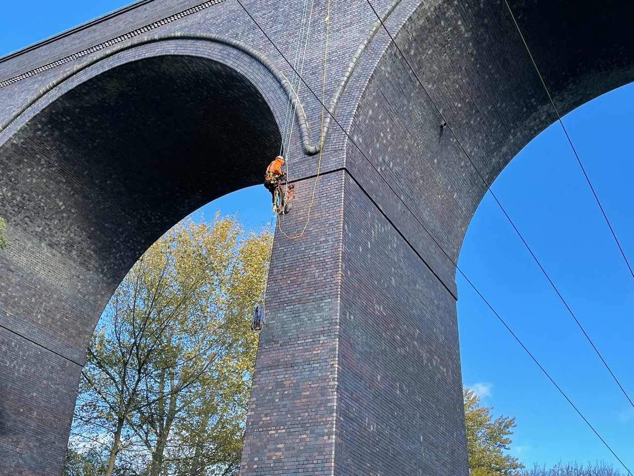 Roped worker installing new bat tubes