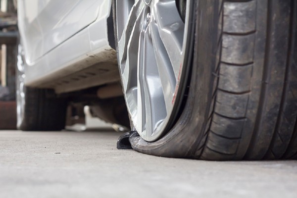 Car with a flat tire in a live traffic lane