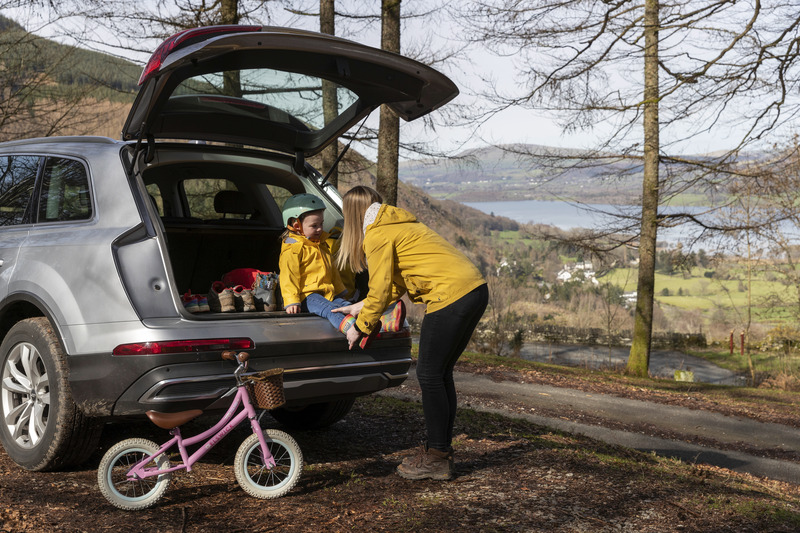 Parent and child standing by their car